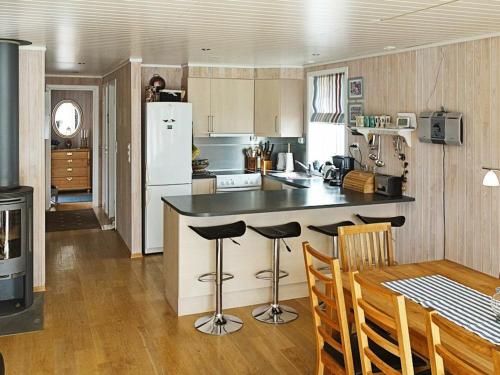 uma cozinha com um balcão e uma mesa com cadeiras em Four-Bedroom Holiday home in Gurskøy 1 em Kjellsund