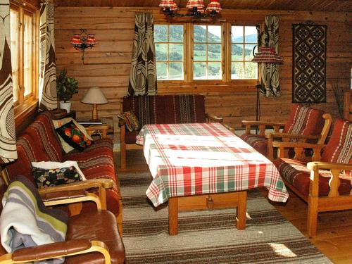 una sala de estar con mesa y sillas en una cabaña en Four-Bedroom Holiday home in Olden 1, en Olden