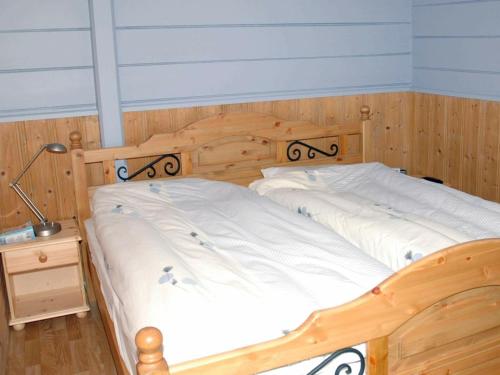 a wooden bed with a wooden headboard in a room at Three-Bedroom Holiday home in Isfjorden in Torvik