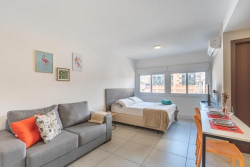 uma sala de estar com um sofá e uma cama em Apartamento incrível Pueblo 595 em Porto Alegre