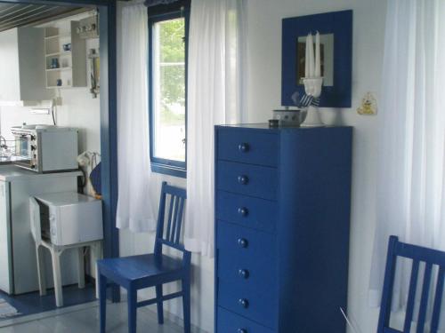 Cette chambre comprend une commode bleue, 2 chaises et une fenêtre. dans l'établissement One-Bedroom Holiday home in Stenungsund, à Stenungsund