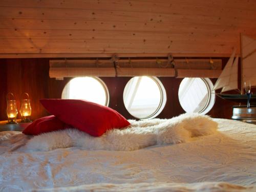 a bed with red pillows and a white blanket at Four-Bedroom Holiday home in Sirevåg in Sirevåg