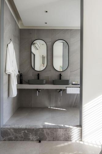 a bathroom with two sinks and two mirrors at Jiufen 35 in Jiufen