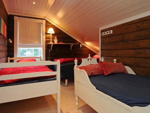 a bedroom with two beds in a room with wooden walls at Holiday Home Vestsiden III in Tromsnes