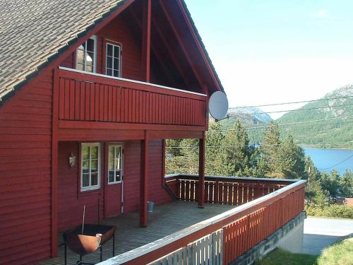 a red house with a deck on the side of it at 27 person holiday home in dyrdal in Frafjord