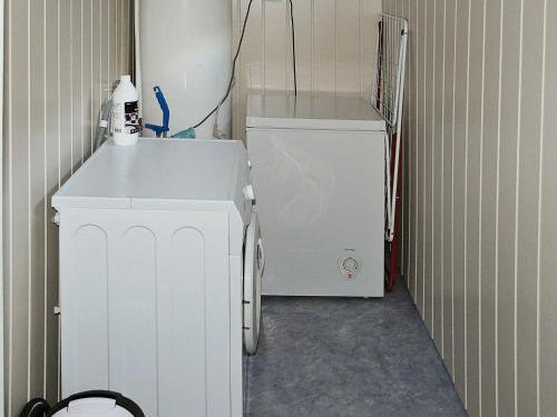 a small white refrigerator next to a white washing machine at 4 person holiday home in Lauvstad-By Traum in Lauvstad