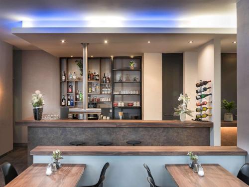 a restaurant with two tables in front of a bar at ibis Styles Hotel Gelsenkirchen in Gelsenkirchen