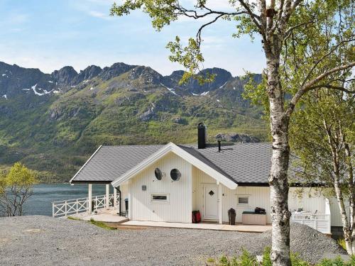 um celeiro branco com montanhas ao fundo em 8 person holiday home in Tengelfjord em Tengelfjorden