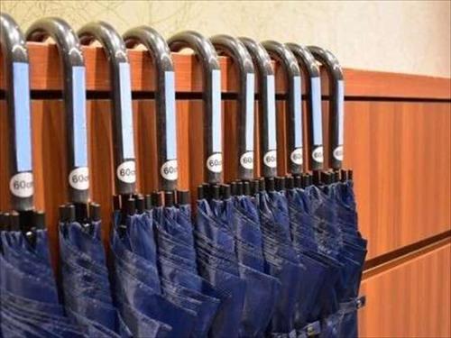 a row of blue umbrellas hanging on a wall at Dormy Inn Hiroshima in Hiroshima