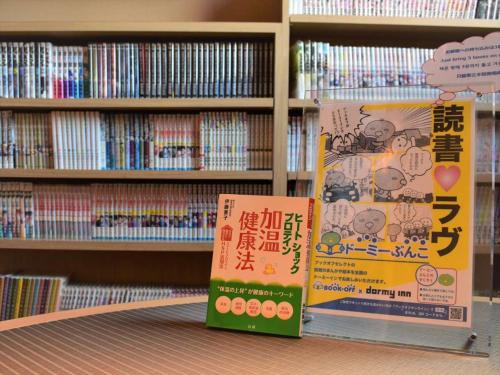 two books sitting on a shelf in a library at Dormy Inn Hiroshima in Hiroshima