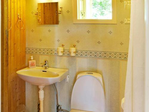 La salle de bains est pourvue d'un lavabo et de toilettes. dans l'établissement One-Bedroom Holiday home in Hästveda, à Lur