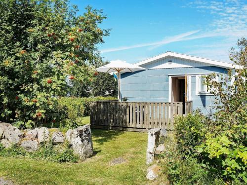 a blue house with an umbrella in the yard at 6 person holiday home in FALKENBERG in Falkenberg