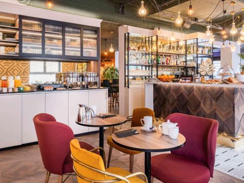 un restaurant avec deux tables et des chaises ainsi qu'un comptoir dans l'établissement Mercure Paris Bercy Bibliothèque, à Paris