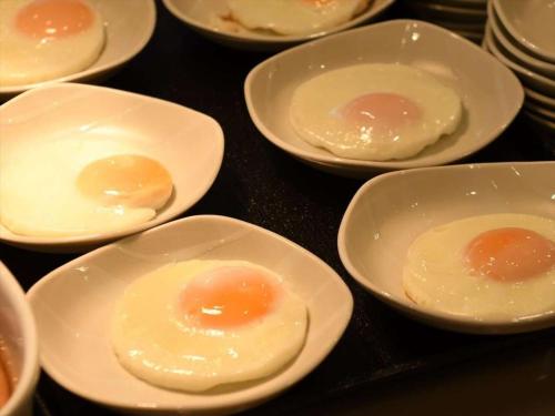 a group of eggs in white bowls on a table at Dormy Inn Hiroshima in Hiroshima