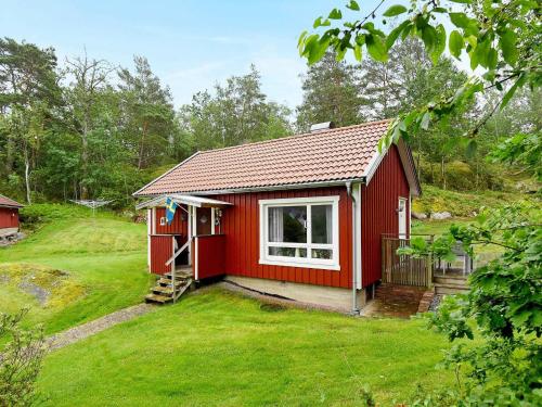 una casita roja en un patio en 4 person holiday home in HEN N, en Nösund