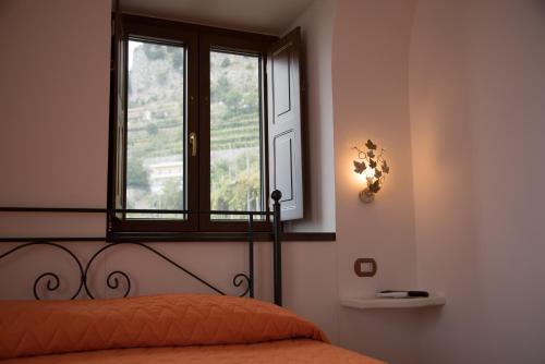 a bedroom with a bed and a window at San Giacomo Relais in Furore