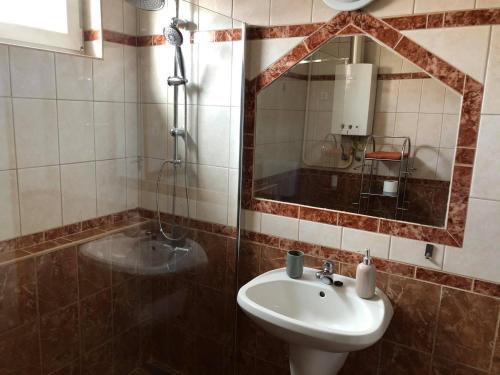 a bathroom with a sink and a mirror at Adél Apartman in Sárvár
