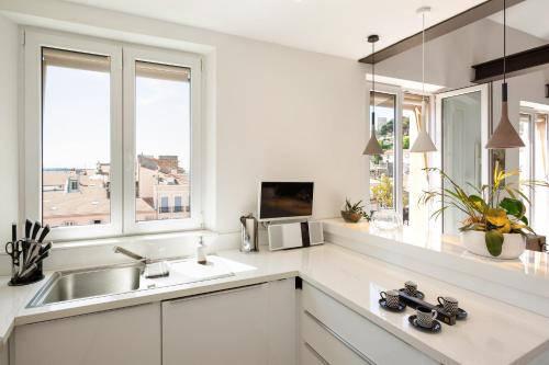 cocina blanca con fregadero y 2 ventanas en Duplex ForVille, en Cannes