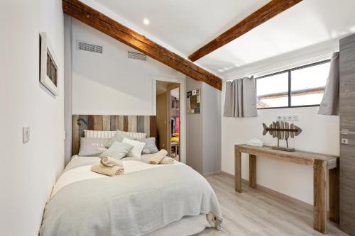 Un dormitorio con una cama grande y una mesa. en Duplex ForVille, en Cannes
