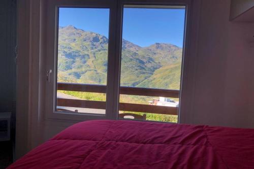 a bedroom with a window with a view of a mountain at Les Ménuires - Appart 2 pièces 4 pers - Balcon plein SUD - Ski aux pieds in Les Menuires