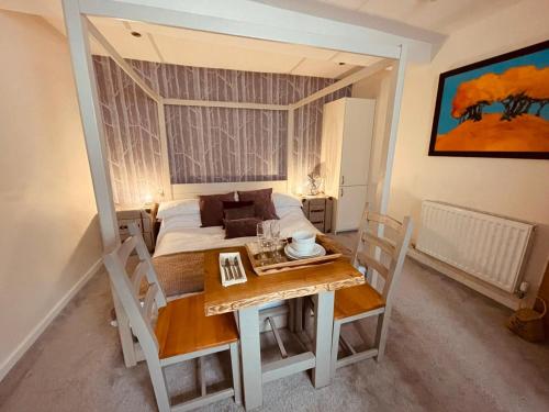 a bedroom with a bed and a table and a table and chairs at The Stowe in Shrewsbury