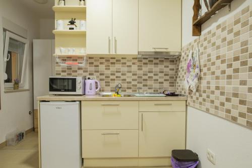 a kitchen with white cabinets and a microwave at Studio Apartments KIM - Dilberovic in Mostar