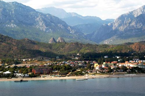 a town on a beach with mountains in the background at Camyuva Beach Hotel in Kemer