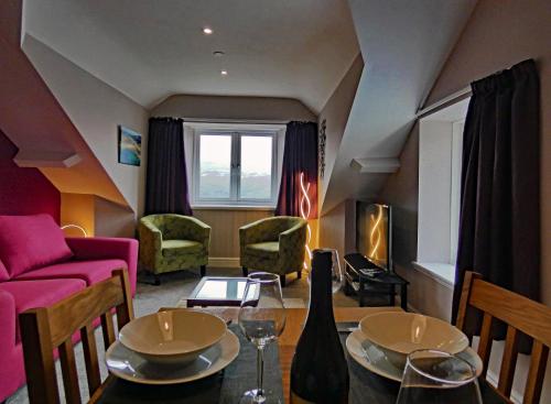 a living room with a couch and a table at Bryn Melyn Apartments in Barmouth