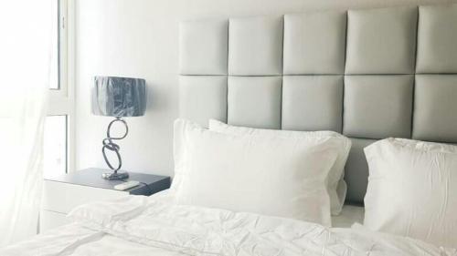 a bedroom with a white bed with a large headboard at Veranda Residence Pattaya by One in Na Jomtien