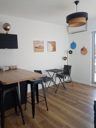 une salle à manger avec tables et chaises et une télévision dans l'établissement Appartement deux pièces , climatisé, terrase, Cavalaire, à Cavalaire-sur-Mer