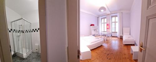 a white room with a bed and a table at Hotel Cranach-Herberge City Centre in Lutherstadt Wittenberg