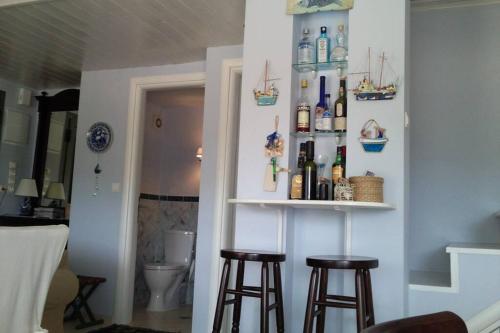 a room with two bar stools and bottles on the wall at VILLEA VILLAGE in Kalamitsi