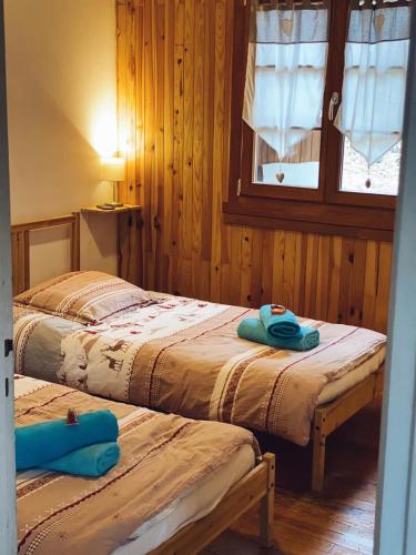 deux lits dans une chambre aux murs en bois dans l'établissement Camping, Hôtel De Plein Air Les Cariamas, à Châteauroux-les-Alpes