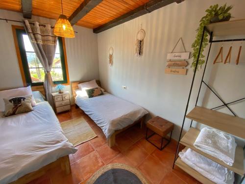 um quarto com duas camas e uma escada em Casa Lagar de Arume em Ponteareas