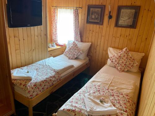 a small room with two beds and a window at Chata Wuja Toma in Szczyrk