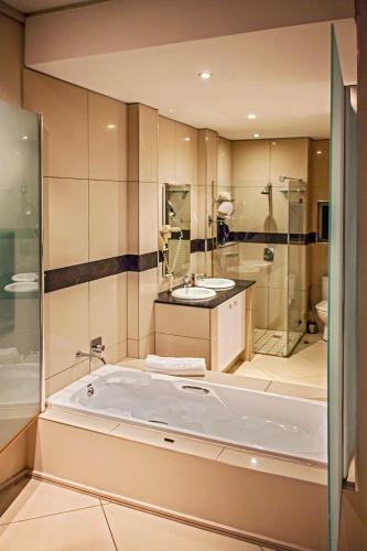 a large bathroom with a tub and a sink at Durban Point Waterfront, 304 The Quays in Durban