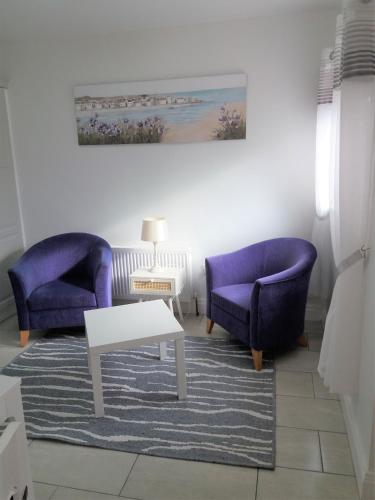 - un salon avec deux chaises violettes et une table dans l'établissement Lettermore Apartment 2, à Rathdrum