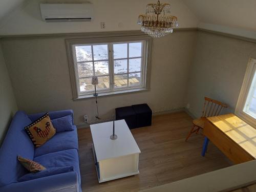 a living room with a blue couch and a table at Sjögårdens gästhus med sovloft in Floby