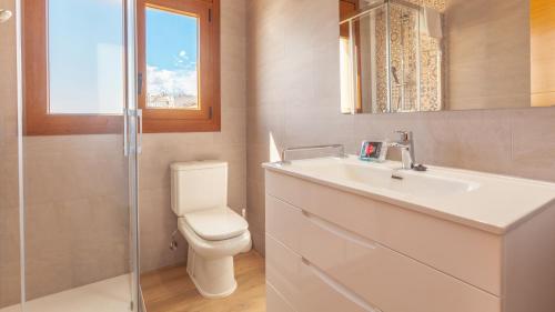 een badkamer met een toilet, een wastafel en een raam bij Voramar B in Calella de Palafrugell