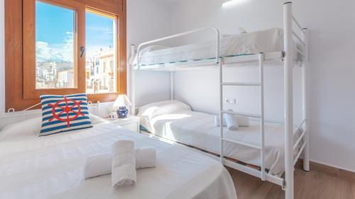 een slaapkamer met 2 stapelbedden en een raam bij Voramar B in Calella de Palafrugell