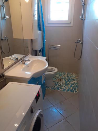 a bathroom with a sink and a toilet and a mirror at condominio guanabara in Lido di Jesolo