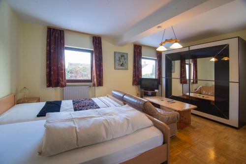 a large bedroom with a large bed and a table at Zum Bergischen Hof in Dormagen