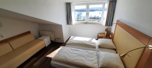two beds in a small room with a window at RUTHMANN-Rheinblick GARNI in Oestrich-Winkel