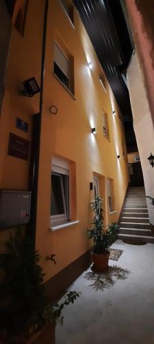 a hallway of a building with stairs and a plant at Studio Apartments KIM - Dilberovic in Mostar