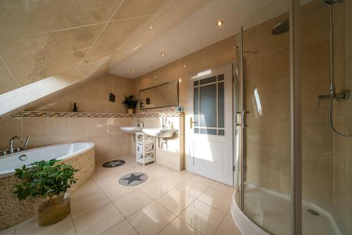 een badkamer met een bad, een wastafel en een douche bij FeWo Kunstquartier in Ziesendorf