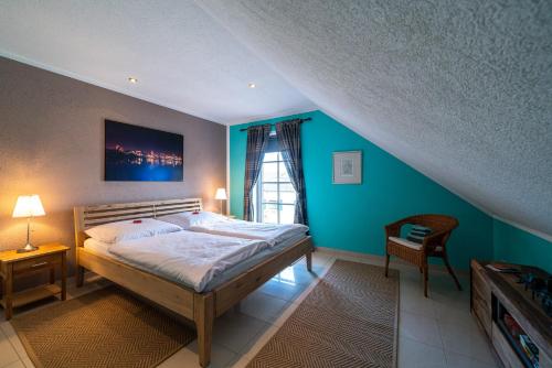 - une chambre avec un lit et un mur bleu dans l'établissement FeWo Kunstquartier, à Ziesendorf