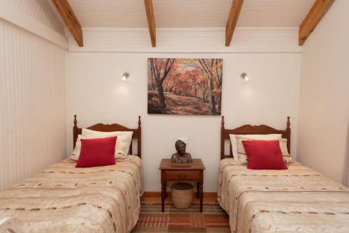 a room with two beds with red pillows at Kamma-Otter in Natureʼs Valley