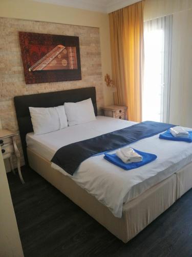 a bedroom with a large bed with towels on it at Sığacık Antik Otel in Siğacık