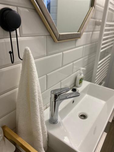 a bathroom sink with a towel hanging on it at APARTMAN PAVIĆ in Vinkovci