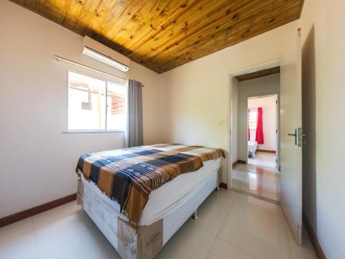 a bedroom with a bed with a wooden ceiling at Apto com lazer em rancho na Praia de Imbassaí - BA in Mata de Sao Joao